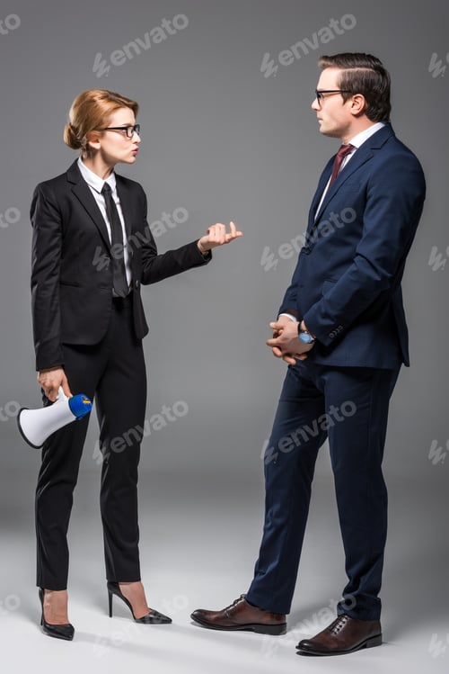 Preview: angry businesswoman with megaphone talking to businessman, isolated on grey