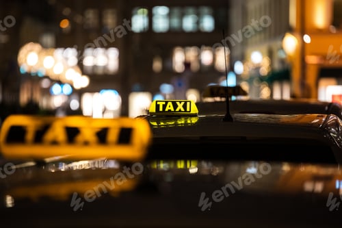 Preview: Yellow TAXI signs on the taxis captured at night