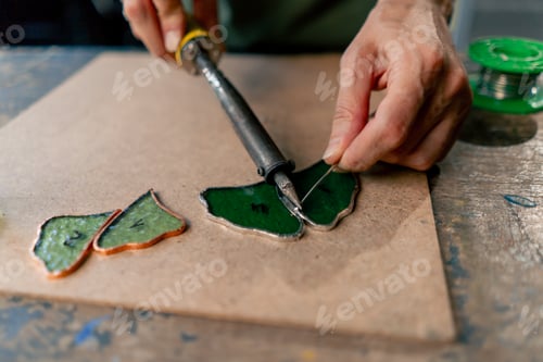 Preview: close up in a large green workshop on a woman with green hair creates decorative flowers working