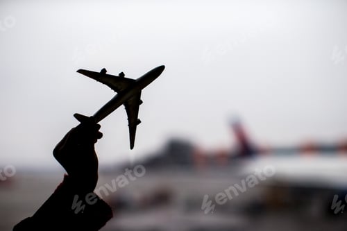 Preview: Silhouette of a small airplane model on airport background