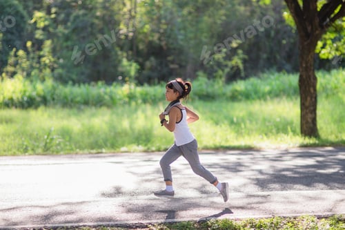 Preview: happy child girl running in the park in summer in nature. warm sunlight flare.