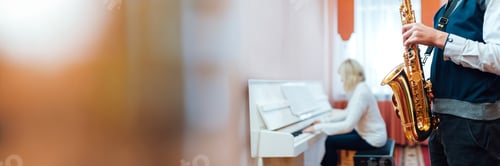 Preview: Woman Plays Piano While Man Holds Saxophone