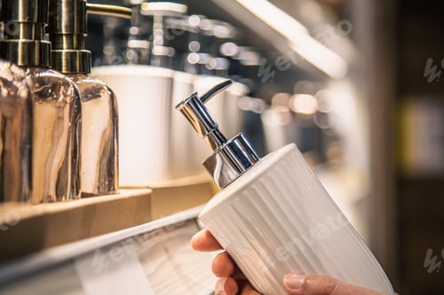 Preview: Close up, a dispenser for liquid soap in female hands in the store.