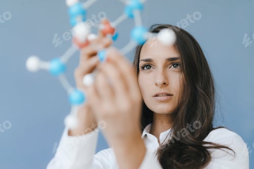 Preview: Female scientist holding molecule model, looking for solutions