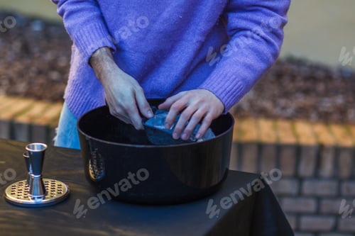 Preview: caucasian young cool red haired barista mixing a a cocktail in shaker with energy outdoors