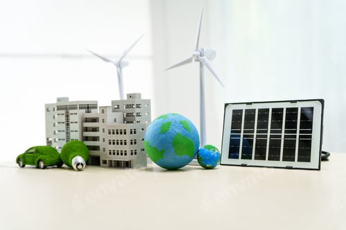 Preview: A white desk displays a model of an electric car, a green light bulb, and solar cells. net zero