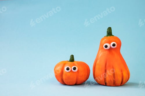 Preview: Funny pumpkin with eyes on a blue background. Side view, place for text.