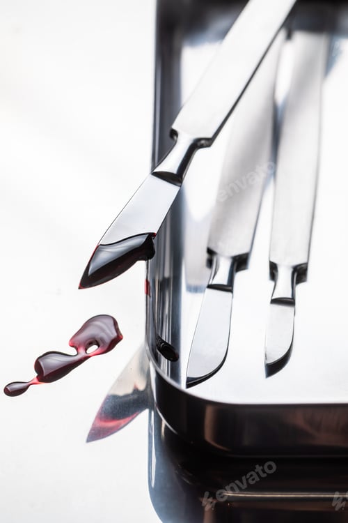 Preview: Closeup of scalpels on stainless steel table with red blood