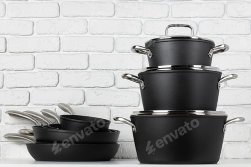 Preview: Set of cookware on table against white brick wall