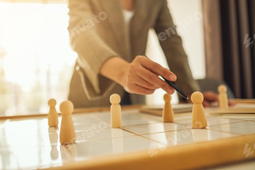 Preview: Businesswoman leader choosing and pointing at one of wooden people from a group of employees
