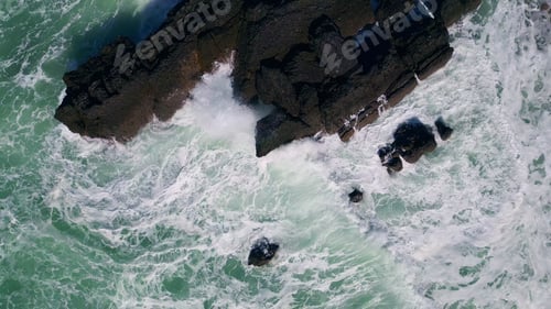 Preview: Foaming sea water breaking on stone cliff. Aerial stormy rough ocean crashing