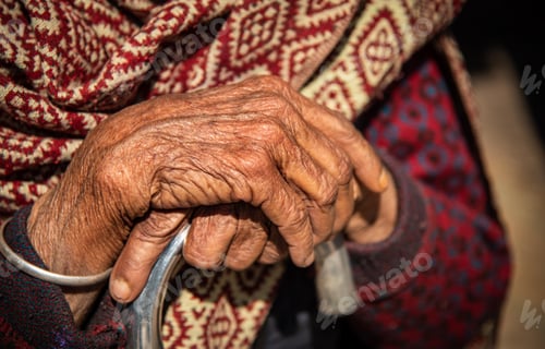 Preview: Close up of the crossed wrinkle hands of an elder grandmother nepalese woman