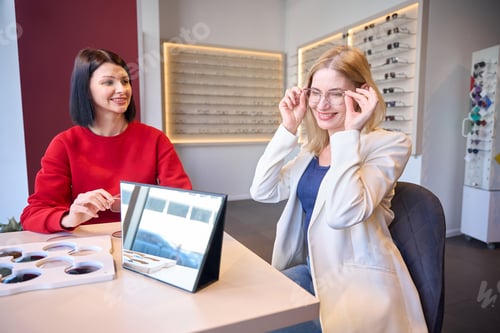 Preview: Woman tries on glasses in an eyewear store