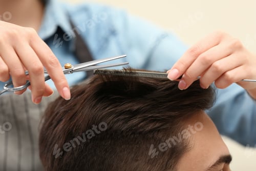 Preview: Barber making stylish haircut with professional scissors in beauty salon, closeup