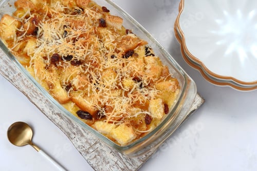 Preview: Homemade bread butter pudding with raisins and grated cheese as topping
