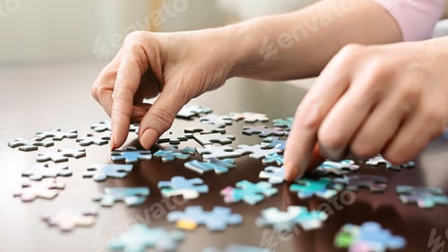 Preview: Elderly woman hands doing jigsaw puzzle closeup