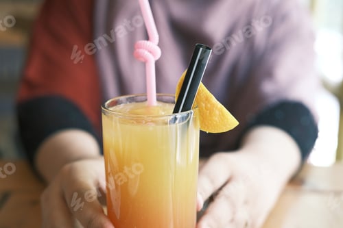 Preview: women hand holding a glass of orange juice