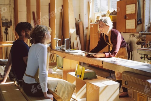 Preview: Three craft workers having an informal meeting in pipe organ workshop