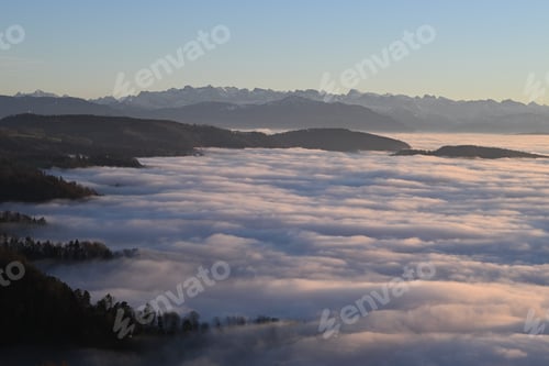 Preview: Fog-covered valley with distant mountain peaks.