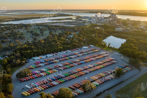 Preview: Aerial view of large cargo container yard with rows of freight containers and big factory