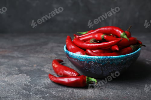 Preview: Bowl with red chili peppers on gray table. Space for text