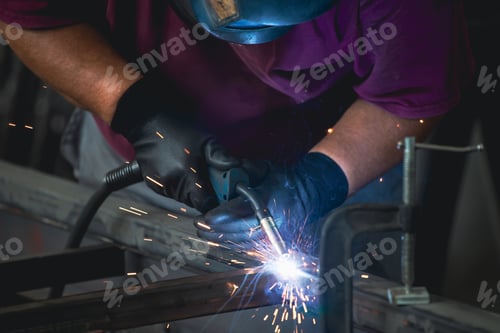 Preview: Industry worker welding iron pieces at work