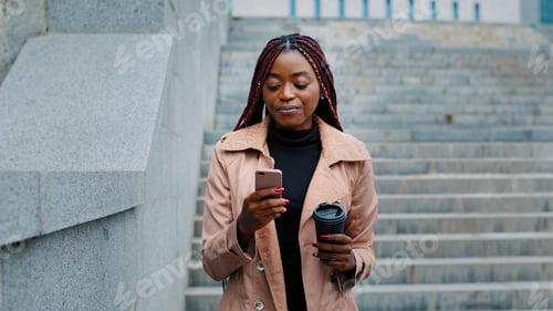 Preview: Close-up young happy woman standing in autumn park communicates video chat on smartphone friendly