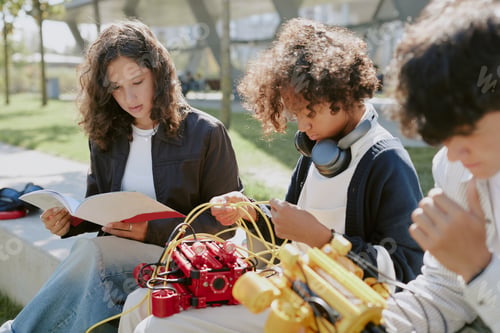 Preview: Boys Holding Robots while Girl Reading Instruction