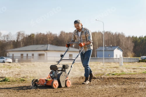Preview: Man using aerator machine to scarification and aeration of lawn or meadow