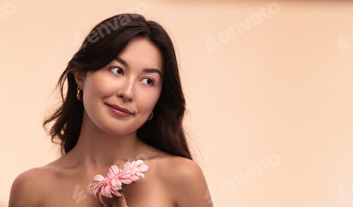 Preview: Young Asian woman with gerbera flower during spa session