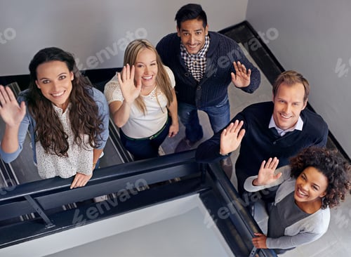 Preview: Theyre a friendly team. Business colleagues standing on the stairs waving.