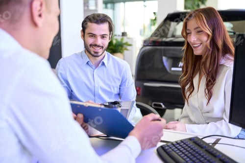 Preview: Automotive dealership salesperson demonstrating contract to car buyers