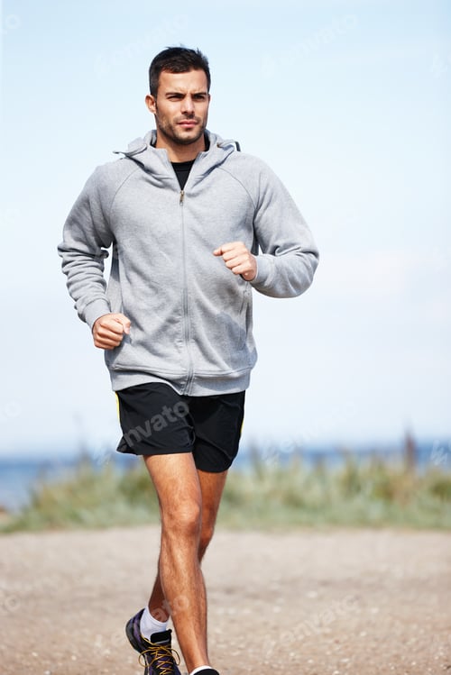 Preview: Taking a morning jog on the beach. Shot of a handsome young man running on the beach.