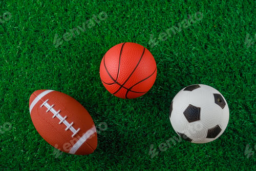 Preview: Sport background soccer, volleyball and football balls on green grass.
