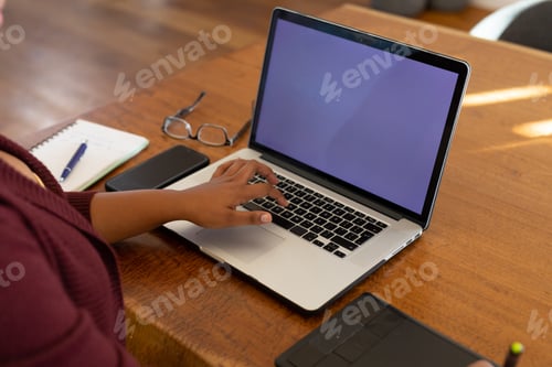 Preview: Midsection of plus size african american woman using laptop with copy space and drawing tablet