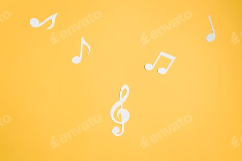 Preview: Musical notes and treble clef cut from paper, flat lay yellow background. Music layout top view
