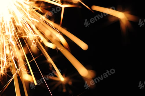Preview: Close-up of golden blurry sparks burn in the dark