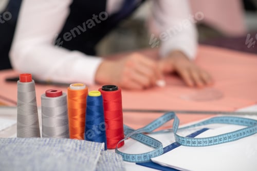 Preview: Hands of male tailor outlining pattern on pink cloth