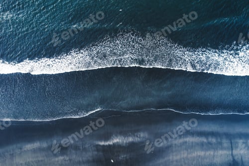Preview: Moody atlantic ocean wave on black sand beach in summer at Iceland