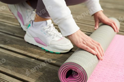 Preview: Woman Rolling Out Yoga Mat on Deck