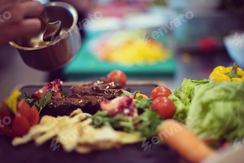 Preview: Chef hand finishing steak meat plate