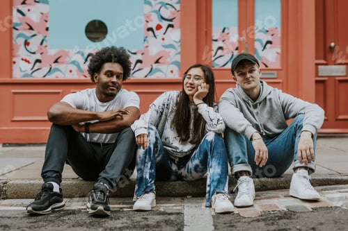 Preview: Diverse friends sitting on sidewalk in front of store