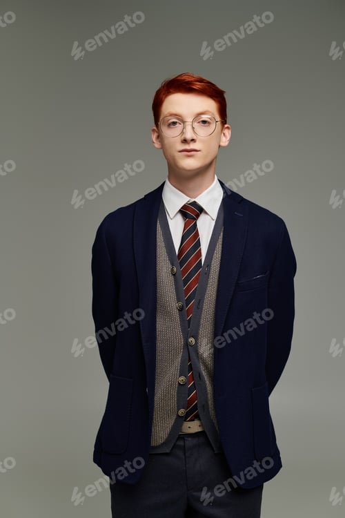 Preview: Red-haired student poses elegantly in winter attire against a studio backdrop