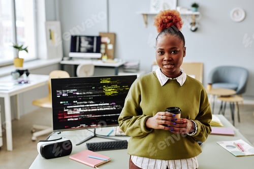 Preview: Black young woman as software programmer smiling at camera in office