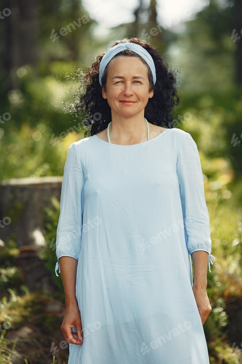 Preview: Stylish adult woman spending time in a summer forest