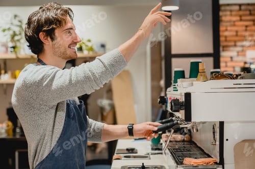 Preview: Young attractive caucasian waiter waiting for orders near cash point in cafeteria