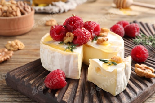 Preview: Brie cheese served with raspberries, walnuts and honey on wooden table, closeup