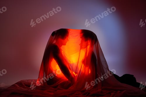 Preview: multiracial couple covered with bedsheet surrounded by light on gray background, togetherness