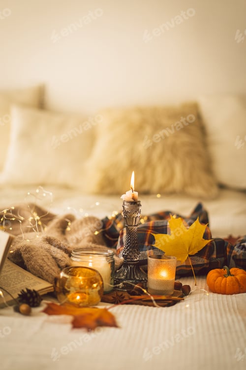 Preview: Sweaters and candles with autumn decor and book. Read, Rest. Still life details in home interior.