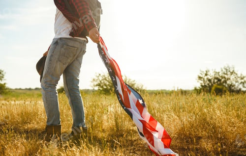 Preview: 4th of July. American Flag. Traveler with the flag of America. The man in a hat, a backpack.